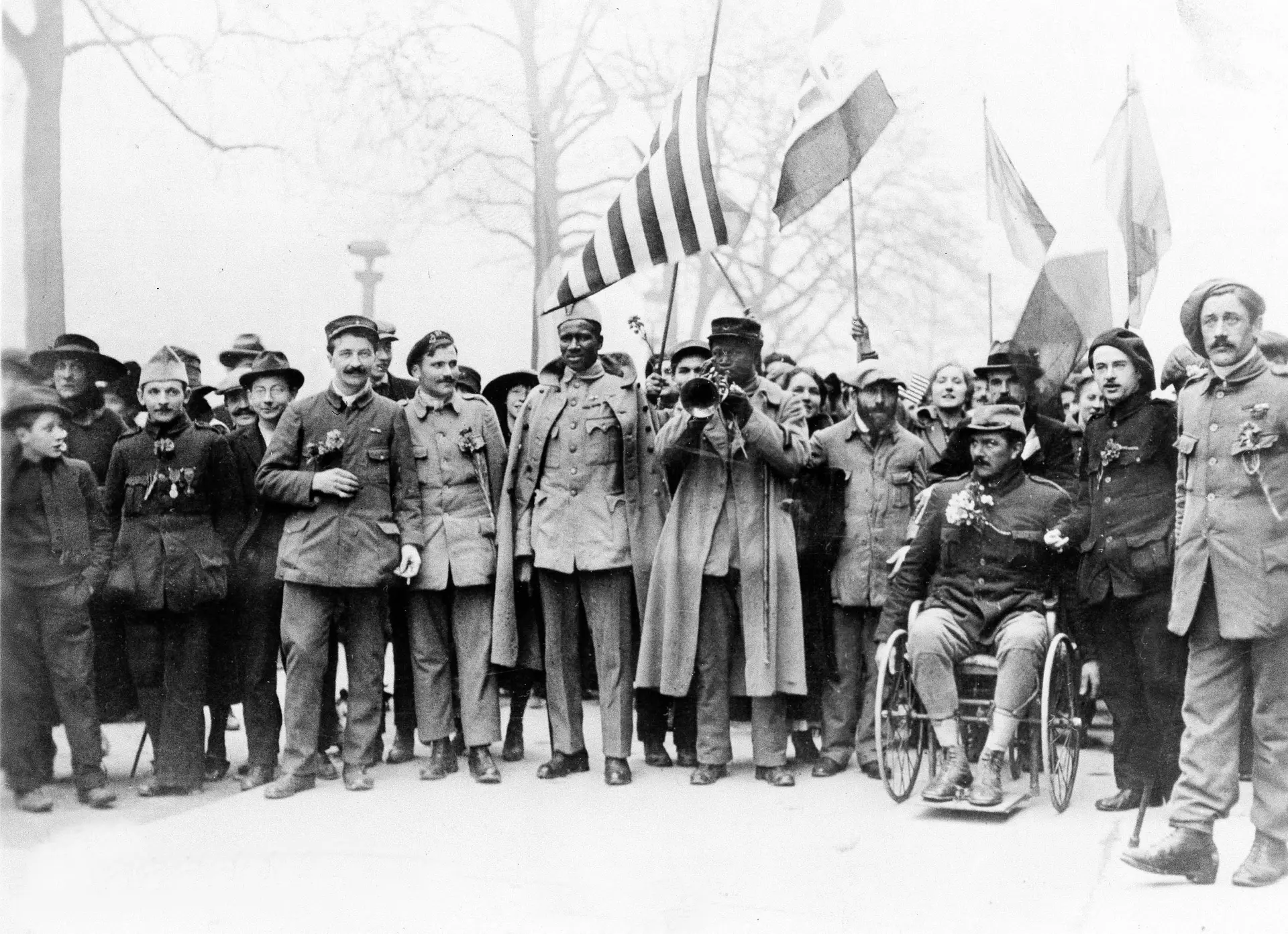 Militares e veteranos de guerra num desfile comemorativo do armistício da Grande Guerra nos Campos Elísios, em Paris, a 11 de novembro de 1918.