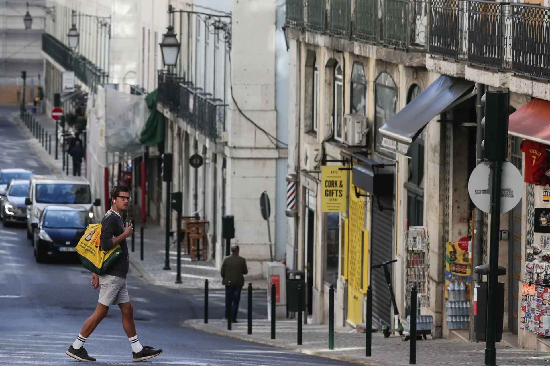 Um turista atravessa a rua da Madalena na zona da baixa pombalina de Lisboa