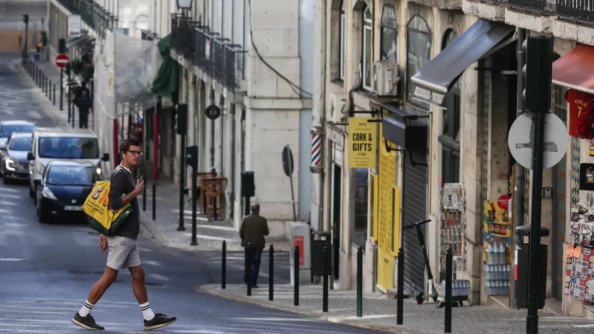 Um turista atravessa a rua da Madalena na zona da baixa pombalina de Lisboa