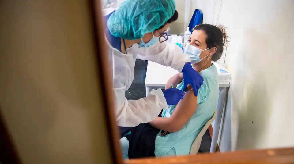 Enfermeira administra a vacina Pfizer-BioNTech a uma profissional de saúde no Hospital de Santa Maria, em Lisboa