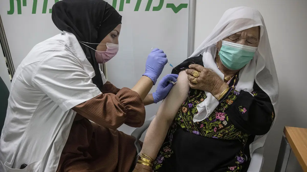 Uma mulher beduína recebe a vacina contra a covid-19 na cidade de Beersjeba, no sul de Israel.