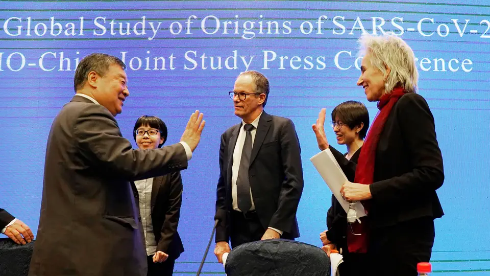 Marion Koopmans e Peter Ben Embarek, da Organização Mundial de Saúde (OMS), despedem-se de Liang Wannian, responsável da OMS-China, no final da missão para identificar a origem da pandemia, em Wuhan, China.