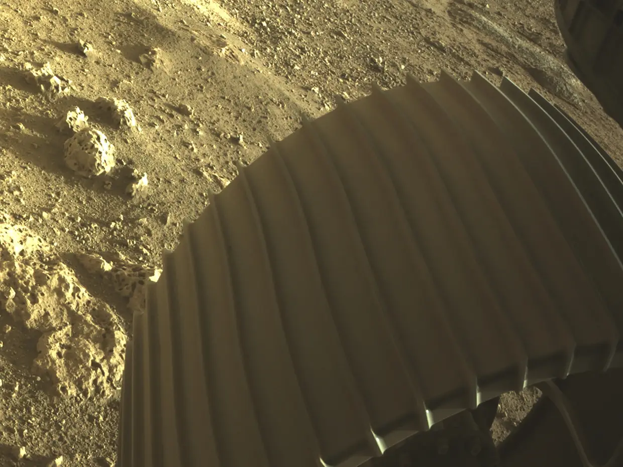 Una de las seis ruedas del diligente robot de Marte de la NASA fue fotografiada por cámaras Hoscoms de alta resolución debajo del rover poco después de que aterrizara en Marte.
