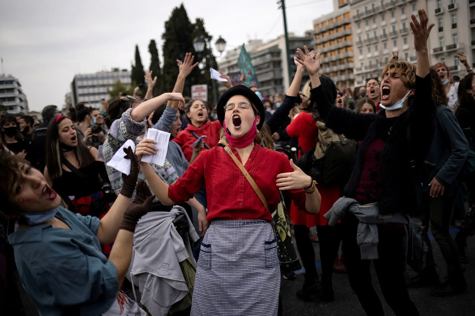 Mulheres e homens dançam e cantam durante uma manifestação para assinalar o Dia Internacional da Mulher em frente ao Parlamento grego em Atenas, Grécia.