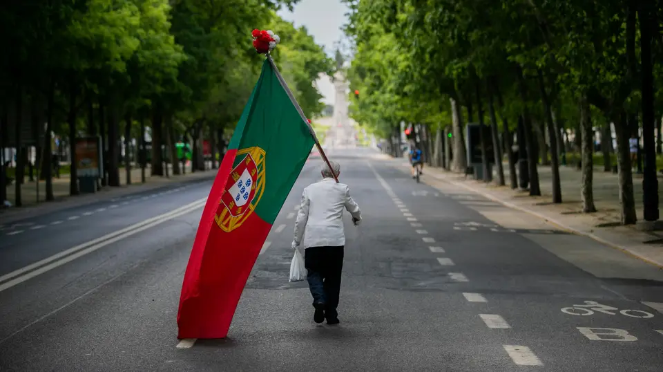 Foto datada de 25/04/2020: Um homem com uma bandeira de Portugal sobe a Avenida da Liberdade em Lisboa, altura em que anualmente se realiza um desfile comemorativo do 25 de abril de 1974 e que, devido à pandemia da covid-19, não pode ter lugar, em Lisboa.