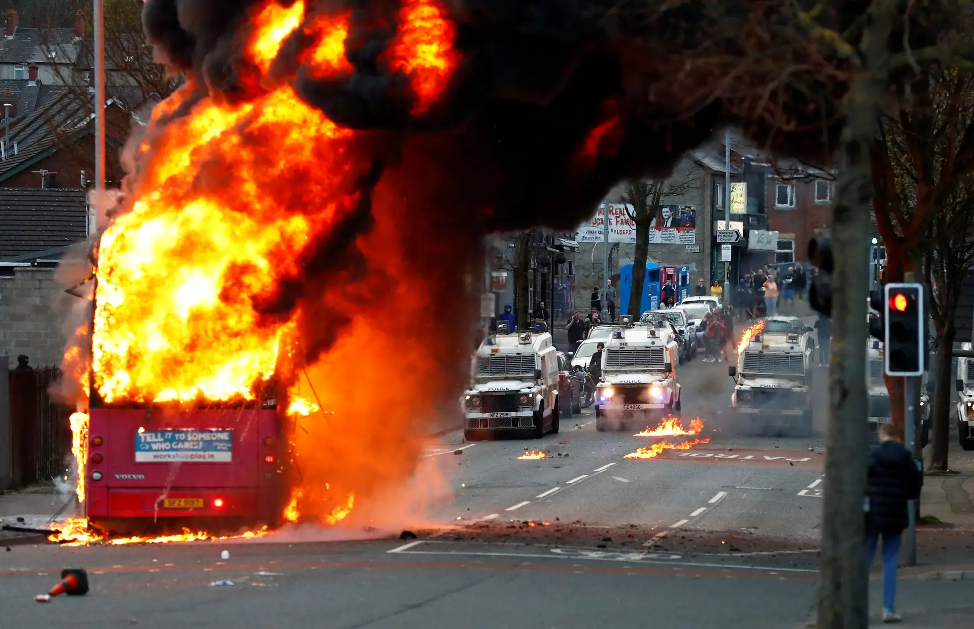Autocarro em chamas, seguido de várias viaturas da polícia, em mais um dia de distúrbios em Belfast. Os protestos sucedem-se na Irlanda do Norte, em reação às regras comerciais pós-Brexit e ao agravamento das relações entre o Partido Unionista Democrático e o Sinn Féin, que integram o Governo de coligação.