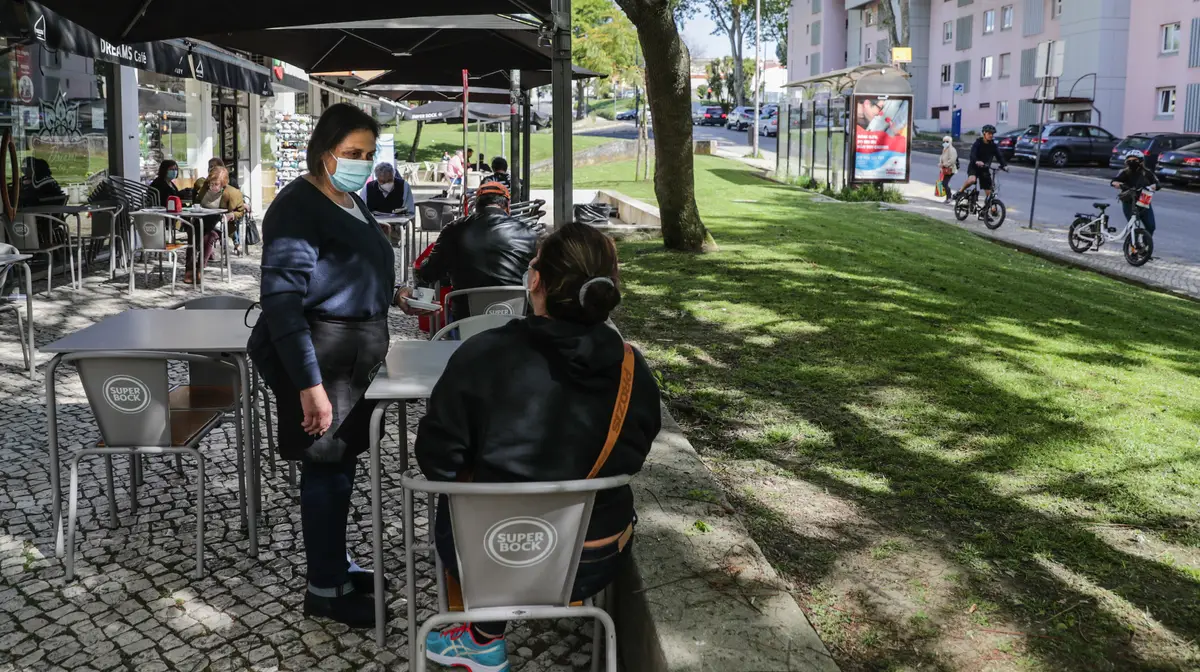 Cristina Almeida atende uma cliente no seu estabelecimento em Telheiras em dia de reabertura das esplanadas, no âmbito do plano de desconfinamento de Portugal continental, Lisboa