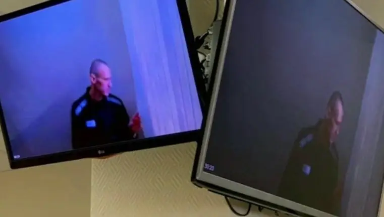 Imagem de Navalny nos ecrã das televisões da sala de tribunal