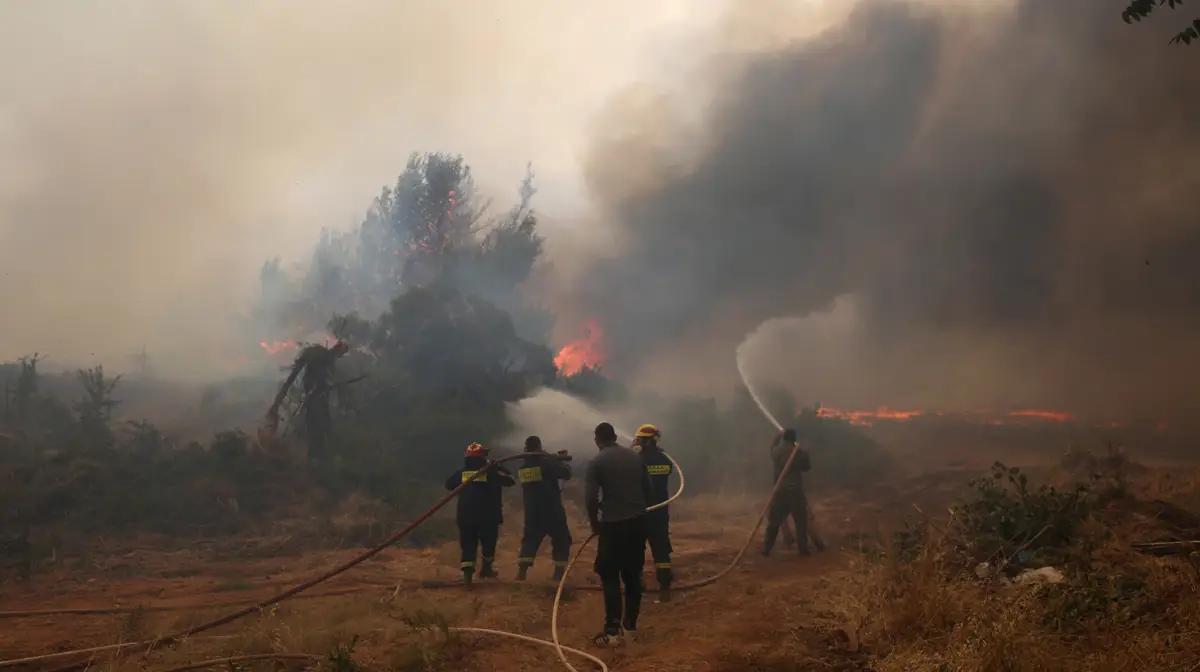 Bombeiros voluntários combatem um incêndio em Kryoneri, perto de Atenas, Grécia.
