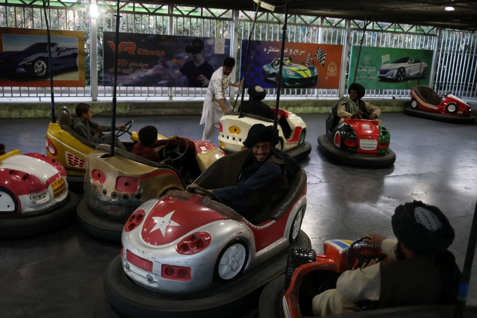 Talibãs em carrinhos de choque num parque de diversões em Cabul