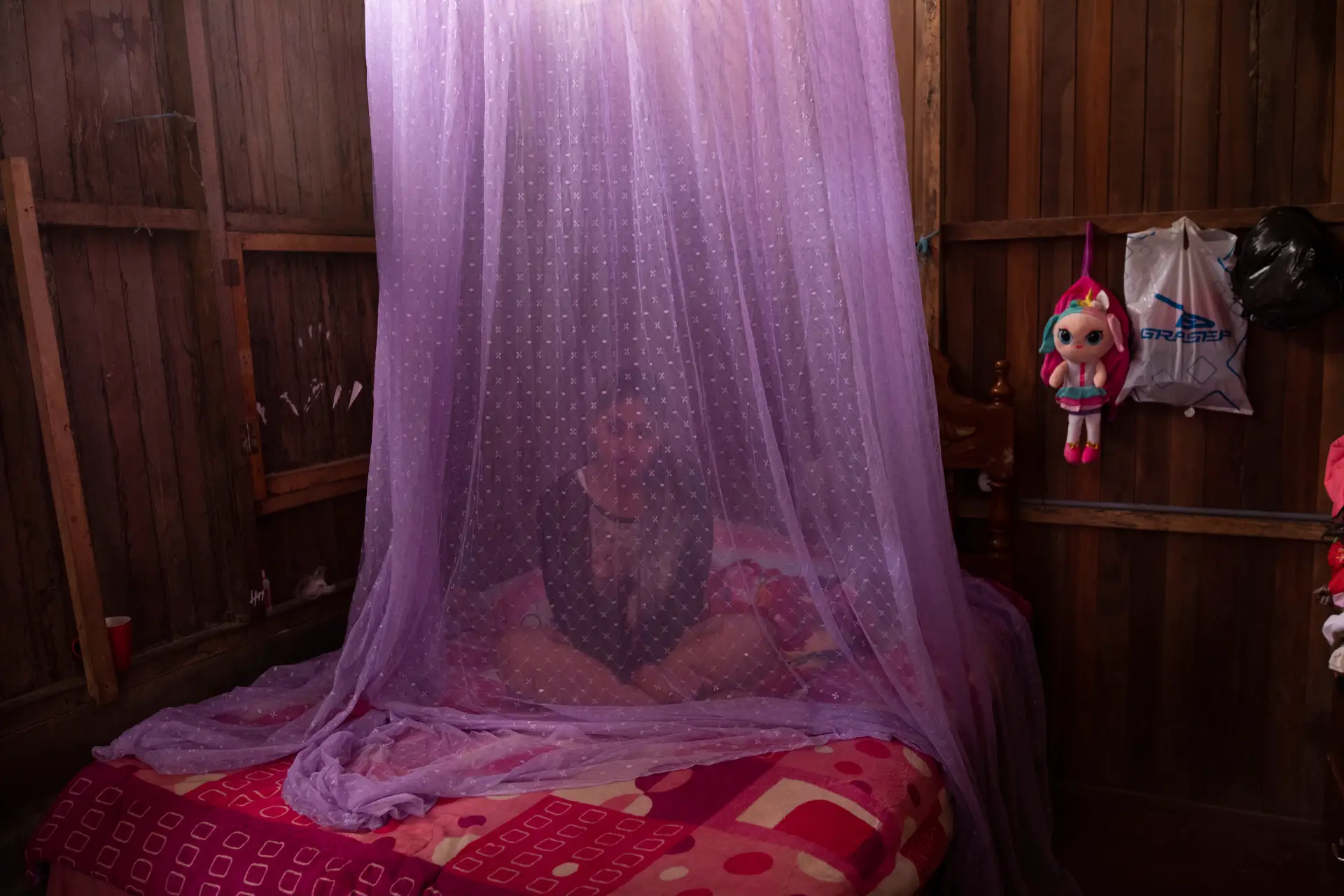Valentina Esperanza recupera da dengue, na sua cama protegida por mosquiteiros em Pucallpa, Peru. Os problemas de saúde ligados às mudanças climáticas estão a piorar, alerta um estudo da revista The Lancet.