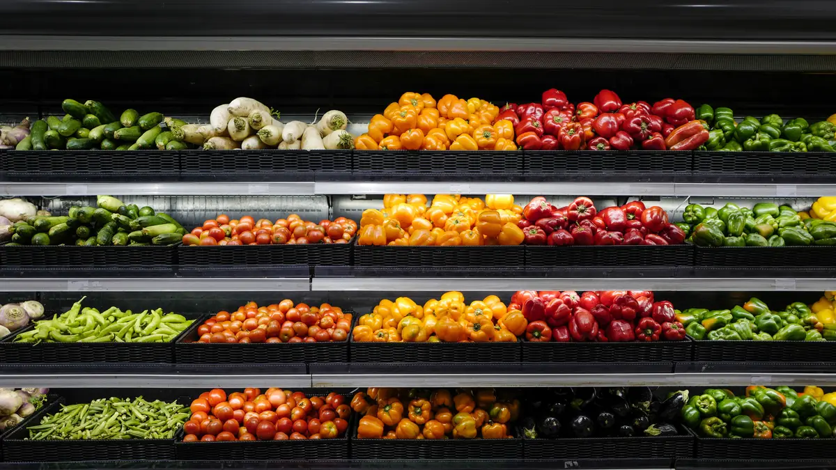 Prateleira de supermercado com hortícolas e outros frescos