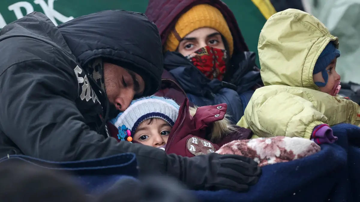 Um casal com duas crianças à espera de uma autorização para entrar na União Europeia, junto à fronteira da Bielorrússia com a Polónia. Milhares de migrantes estão acampados nesta zona de fronteira, onde pelo menos oito migrantes já morreram devido ao frio.