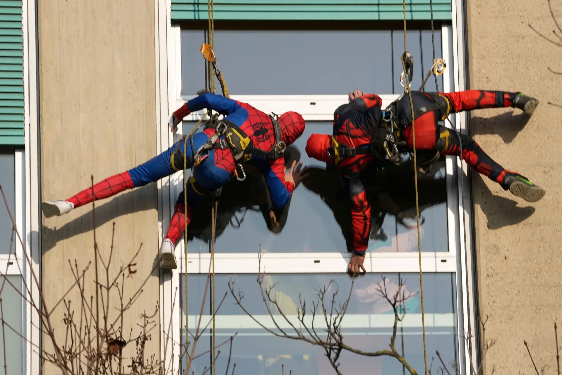 Super-heróis suspensos em cordas surpreendem crianças à janelas do quarto onde estão internadas num hospital pediátrico em Milão, Itália.