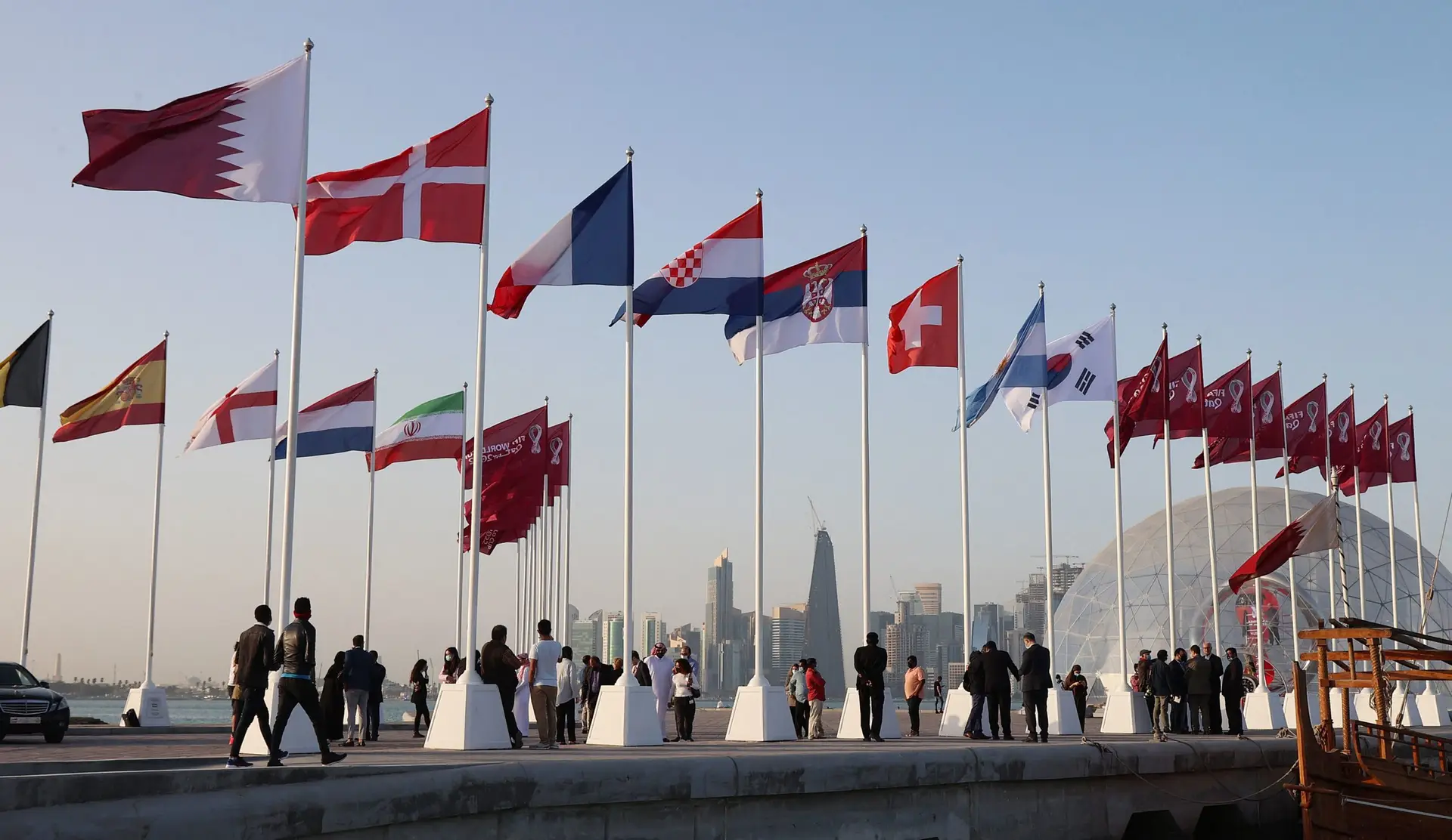 The flags of qualifying nations are raised along the Doha Corniche, in front of the countdown clock on February 3, 2022, as Qatar prepares to host the FIFA World Cup 2022. (Photo by KARIM JAAFAR / AFP) (Photo by KARIM JAAFAR/AFP via Getty Images)