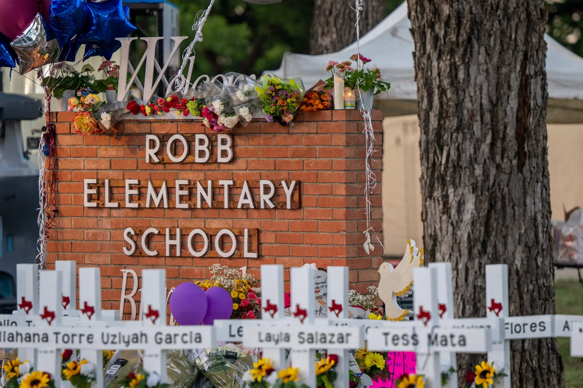 UVALDE, TEXAS – MAY 26: A memorial is seen surrounding the Robb Elementary School sign following the mass shooting at Robb Elementary School on May 26, 2022 in Uvalde, Texas. According to reports, 19 students and 2 adults were killed, with the gunman fatally shot by law enforcement. (Photo by Brandon Bell/Getty Images)