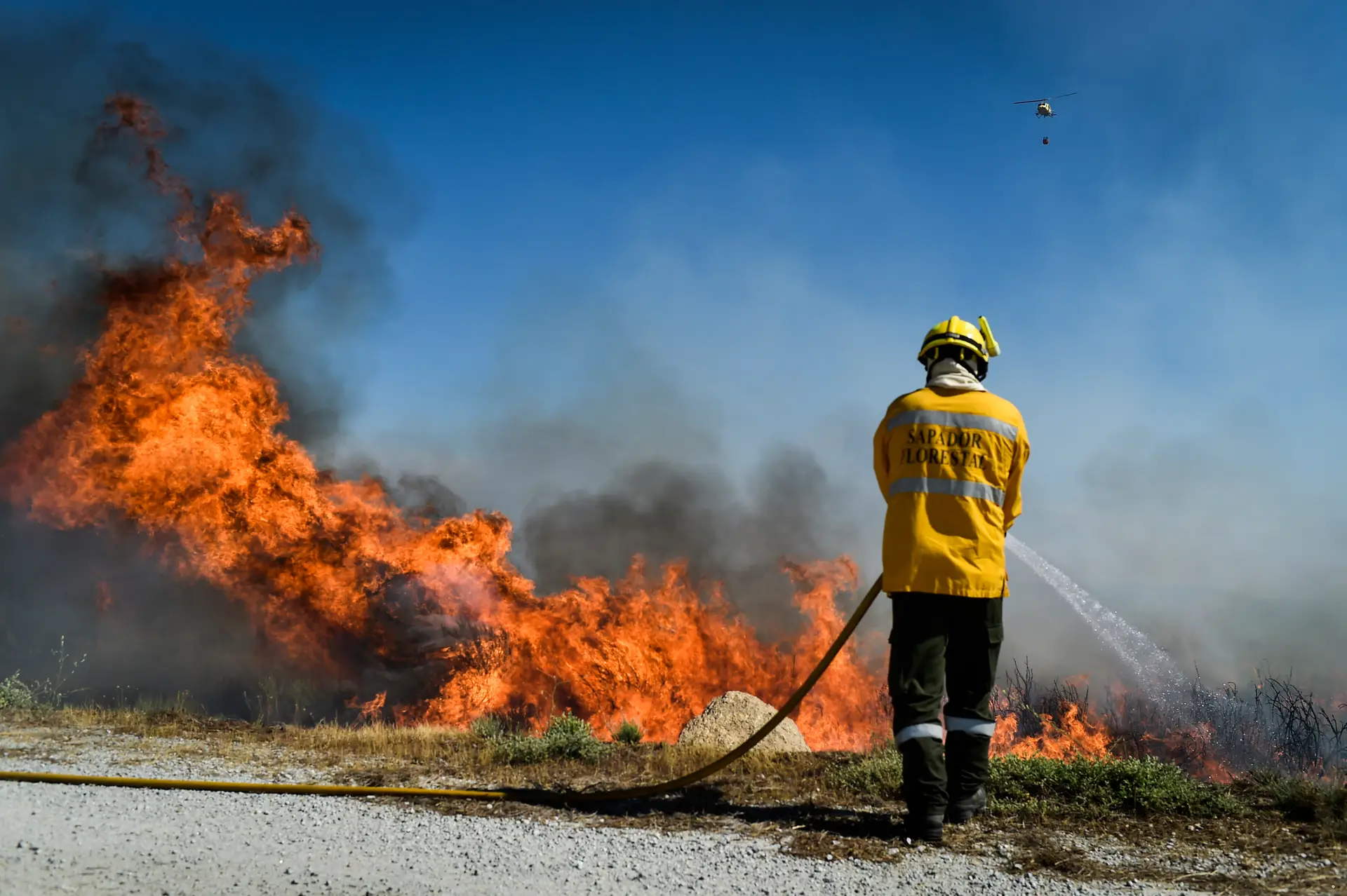 Um bombeiro combate um incêndio na freguesia de Rapa, Celorico da Beira, Guarda.