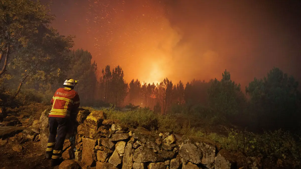 Um bombeiro observa as chamas durante o combate ao incêndio na aldeia de Escariz que se viu envolvida pelas chamas, em Vila Real.