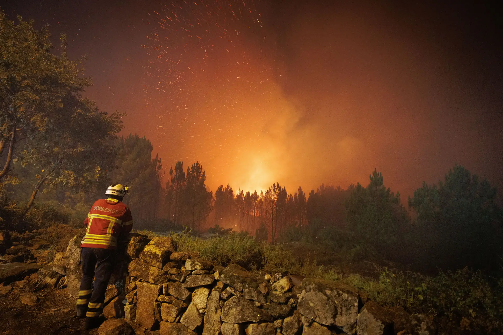 Um bombeiro observa as chamas durante o combate ao incêndio na aldeia de Escariz que se viu envolvida pelas chamas, em Vila Real.