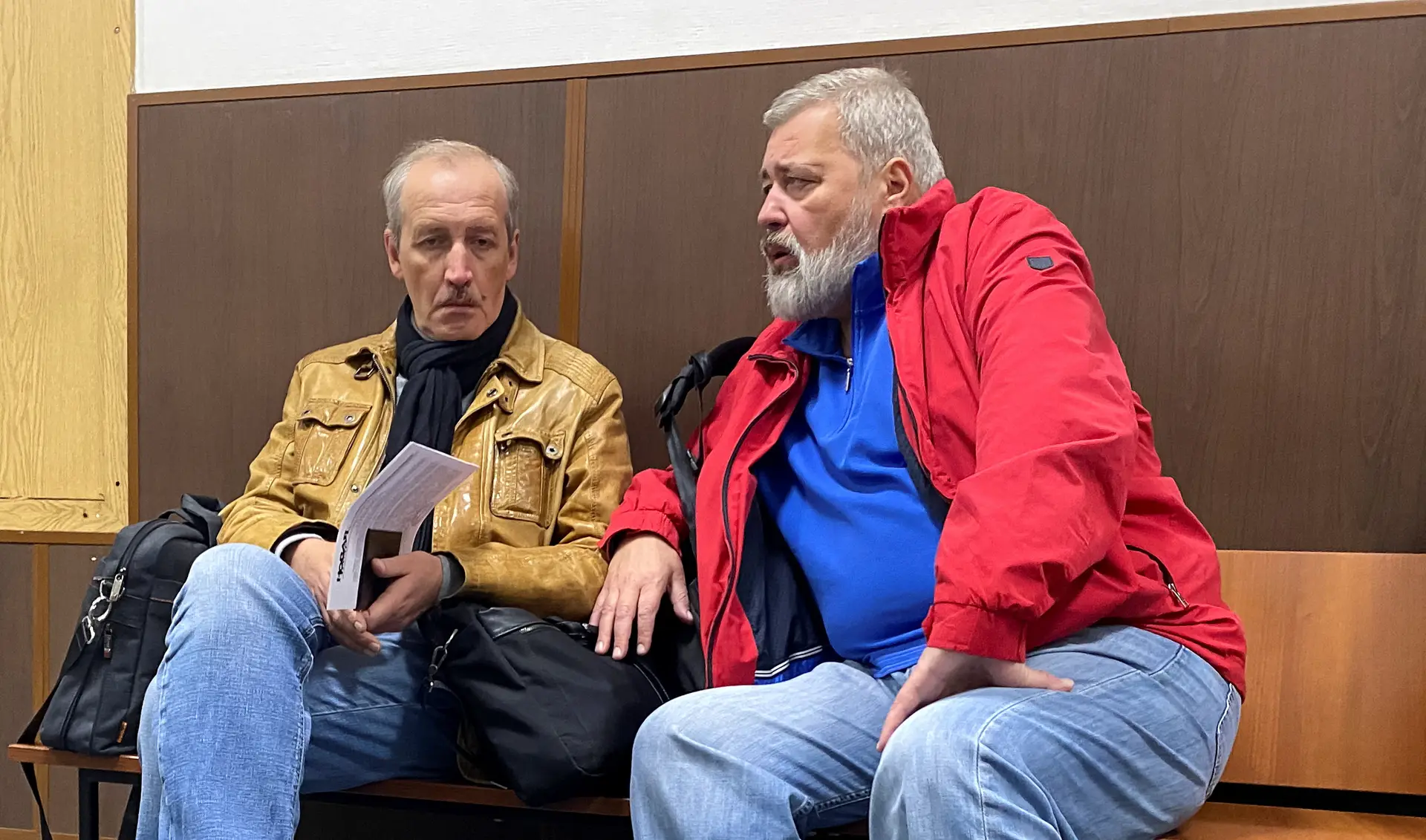 Editor-chefe do jornal Novaya Gazeta, Dmitry Muratov, e o sub-editor-chefe Sergei Sokolov, sentados num corredor do tribunal.