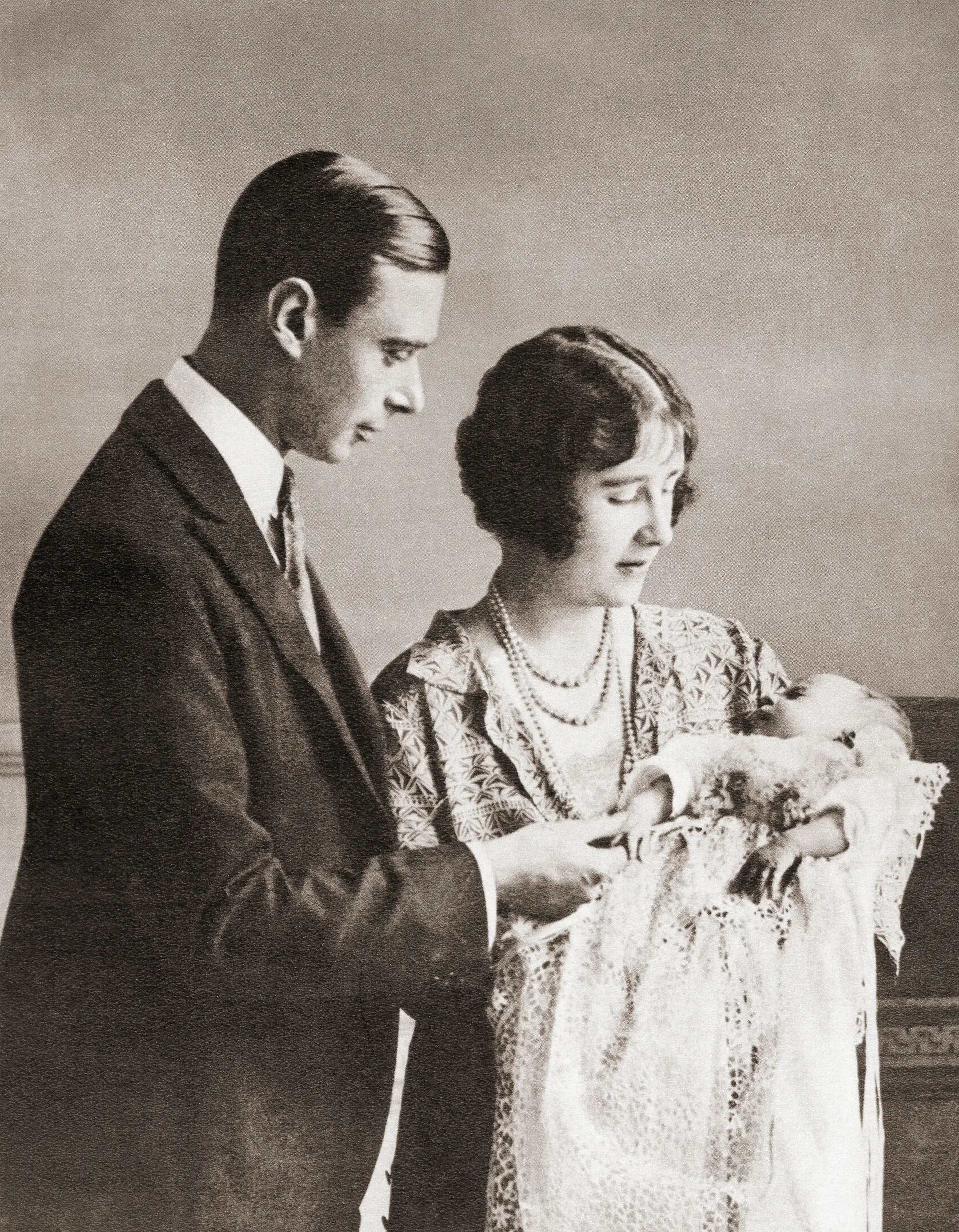 Elizabeth Alexandra Mary, que nasceu a 21 de abril de 1926, ao colo dos pais no ano do seu nascimento.