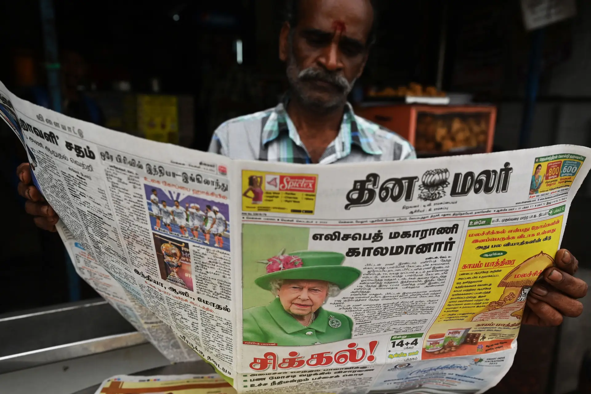Homem lê o jornal em Chennai, na Índia.