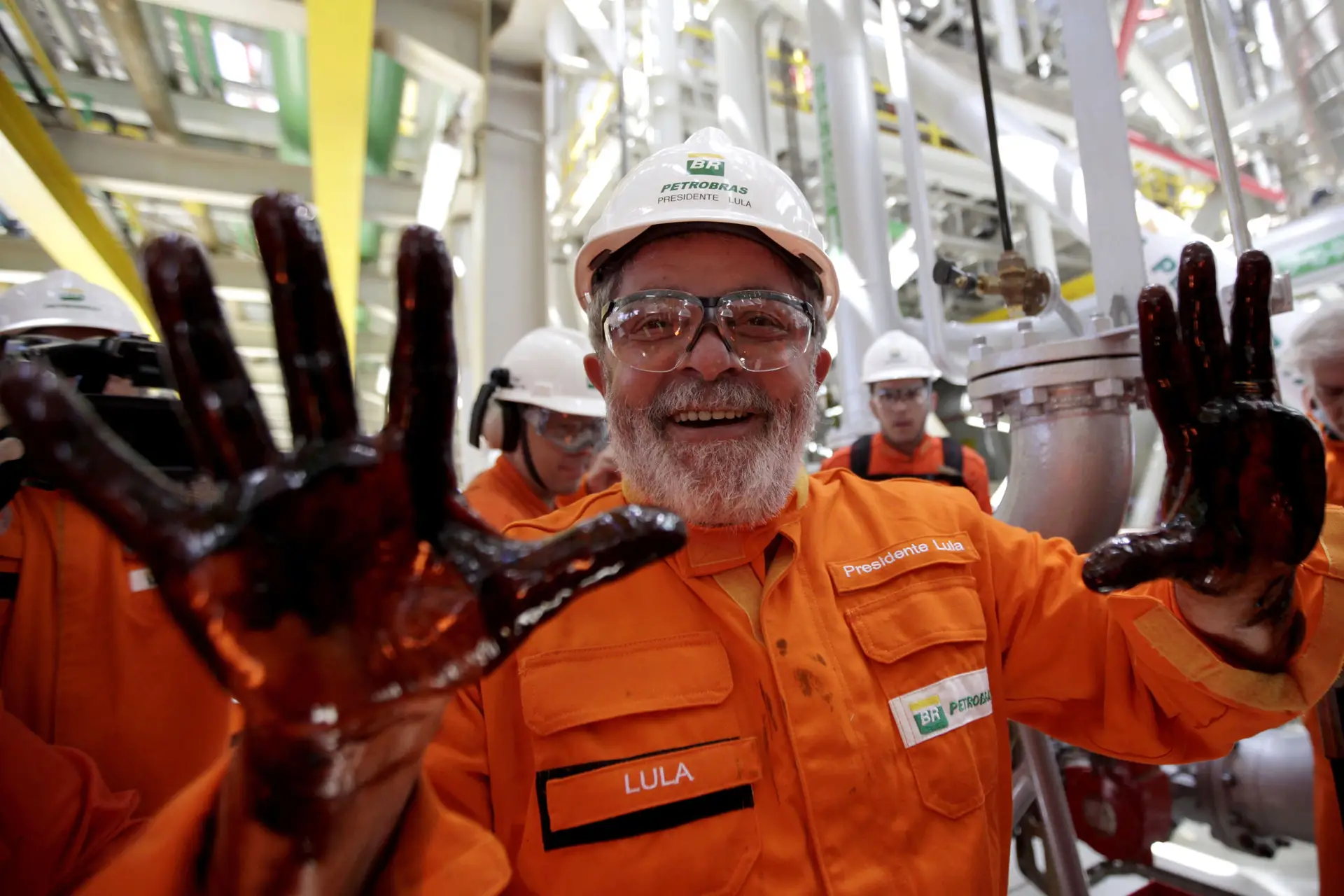Em outubro de 2010, o então Presidente do Brasil mostra as mãos cobertas petróleo durante uma visita a uma plataforma offshore da Petrobras.
