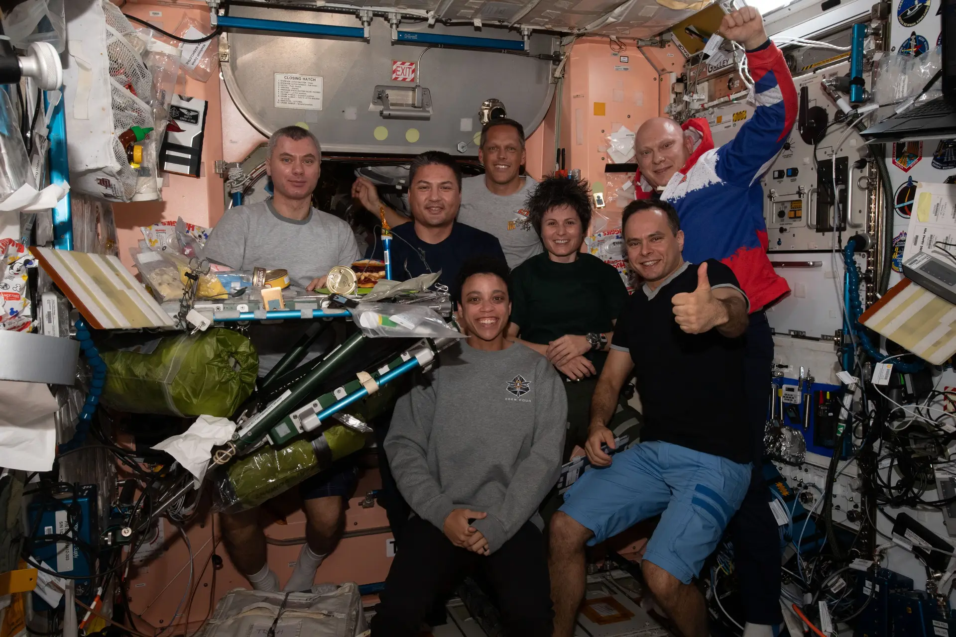 A tripulação da Expedição 67 posa para a fotografia durante um jantar no módulo Unity da Estação Espacial Internacional. Na primeira fila (da esquerda), estão a engenheira de voo da NASA Jessica Watkins e o engenheiro de voo da Roscosmos Sergey Korsakov. Na parte de trás (da esquerda), estão o Engenheiro de Voo da Roscosmos Denis Matveev, os engenheiros de voo da NASA Kjell Lindgren e Bob Hines, a engenheira de voo da ESA Samantha Cristoforetti e o comandante da Roscosmos, Oleg Artemyev.