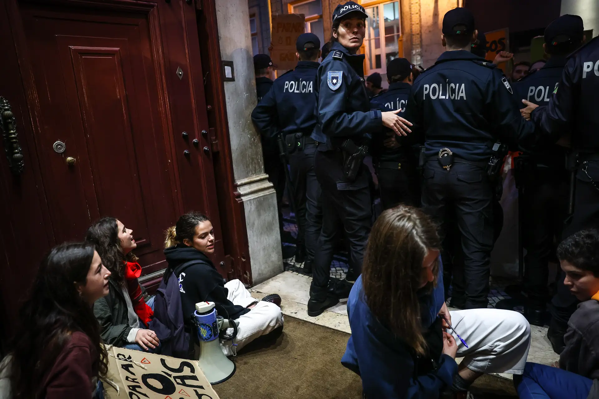 Ativistas sentados em protesto à porta do Ministério da Economia