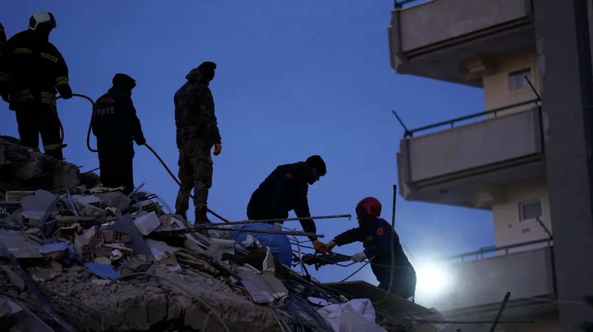 Bombeiros procuram pessoas nos escombros de um edifício destruído, em Gaziantep, no sudeste da Turquia.