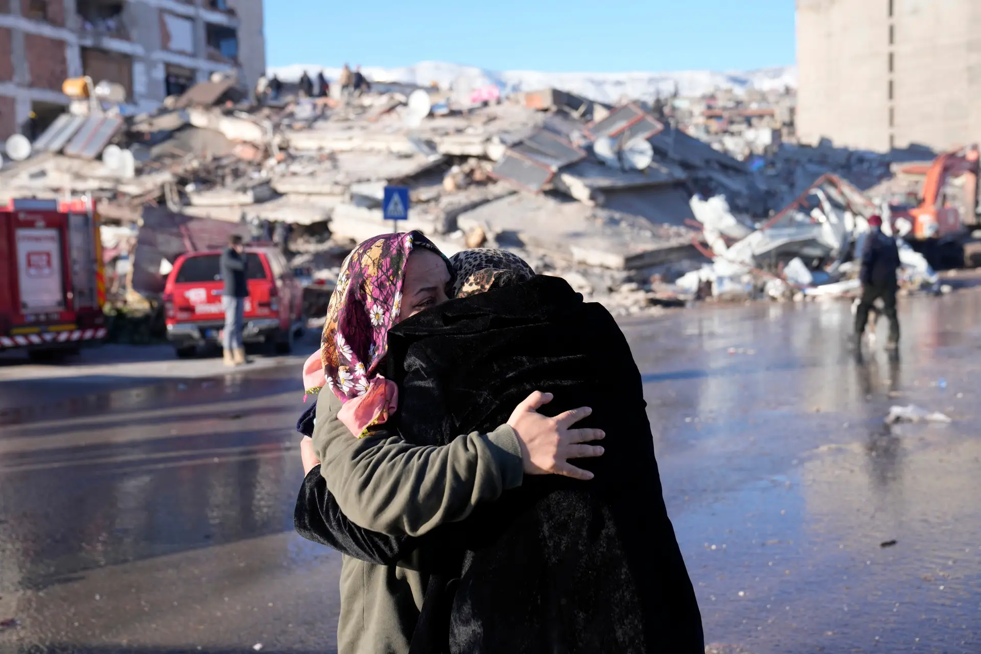 Duas mulheres abraçam-se em frente a um edifício destruído em Kahramanmaras, no sul da Turquia.