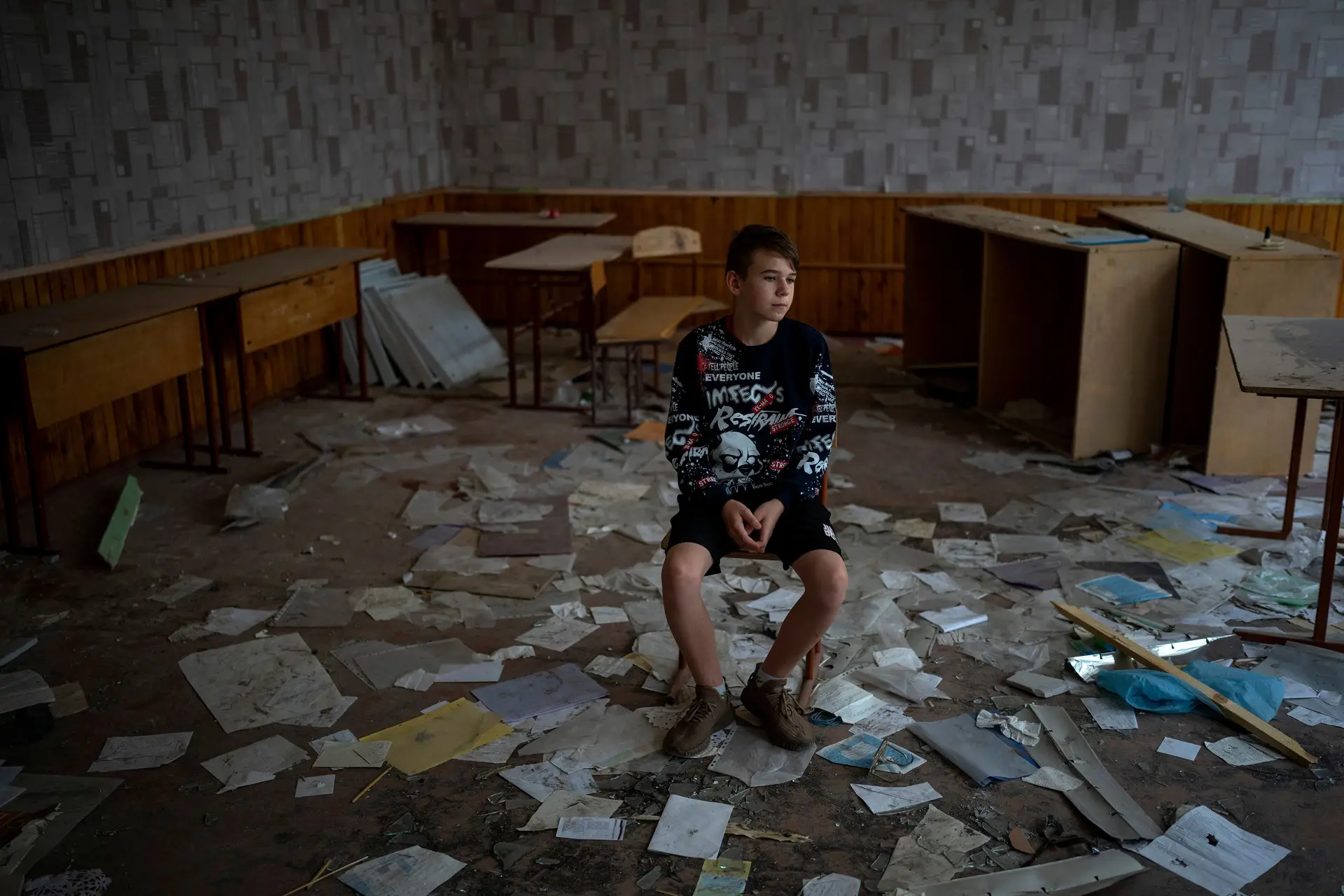 Rapaz de 13 anos sentado no que resta da sua sala de aula na escola de Chernihiv. "Quando estou na minha sala de aula, penso em como quero tanto que a guerra termine", disse à Associated Press.