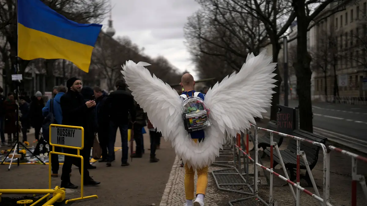 Um homem vestido de pomba da paz em frente à Embaixada Russa durante os protestos que assinalam o primeiro aniversário da invasão da Ucrânia, em Berlim, Alemanha.