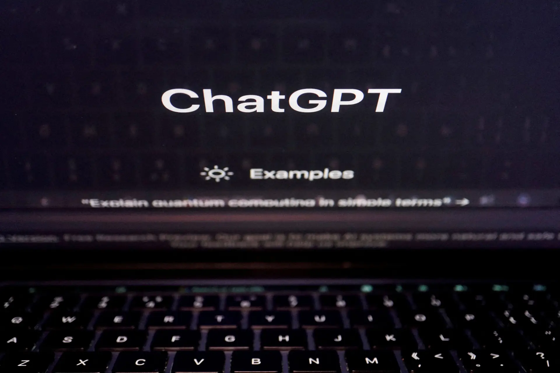 Um teclado é refletido num ecrã de computador que exibe o website do ChatGPT.