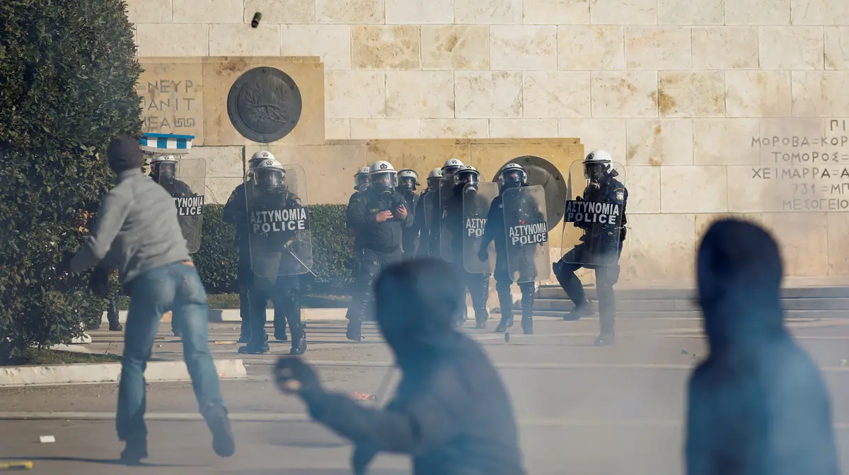 Manifestante em confronto com a polícia de choque grega.