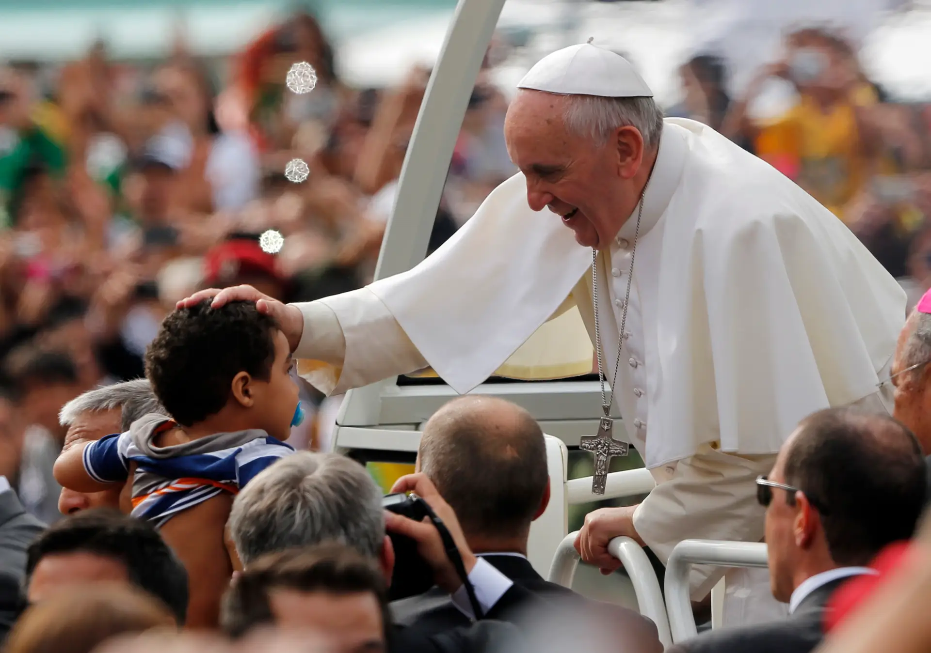 Francisco abençoa uma criança enquanto anda no papamóvel para celebrar a missa no Rio de Janeiro, domingo, 28 de julho de 2013