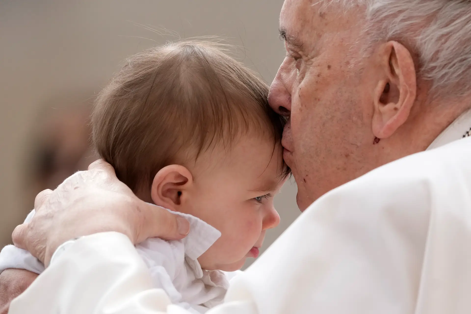 Papa Francisco beija uma criança no final da audiência semanal na Praça de São Pedro no Vaticano,  8 de março de 2023