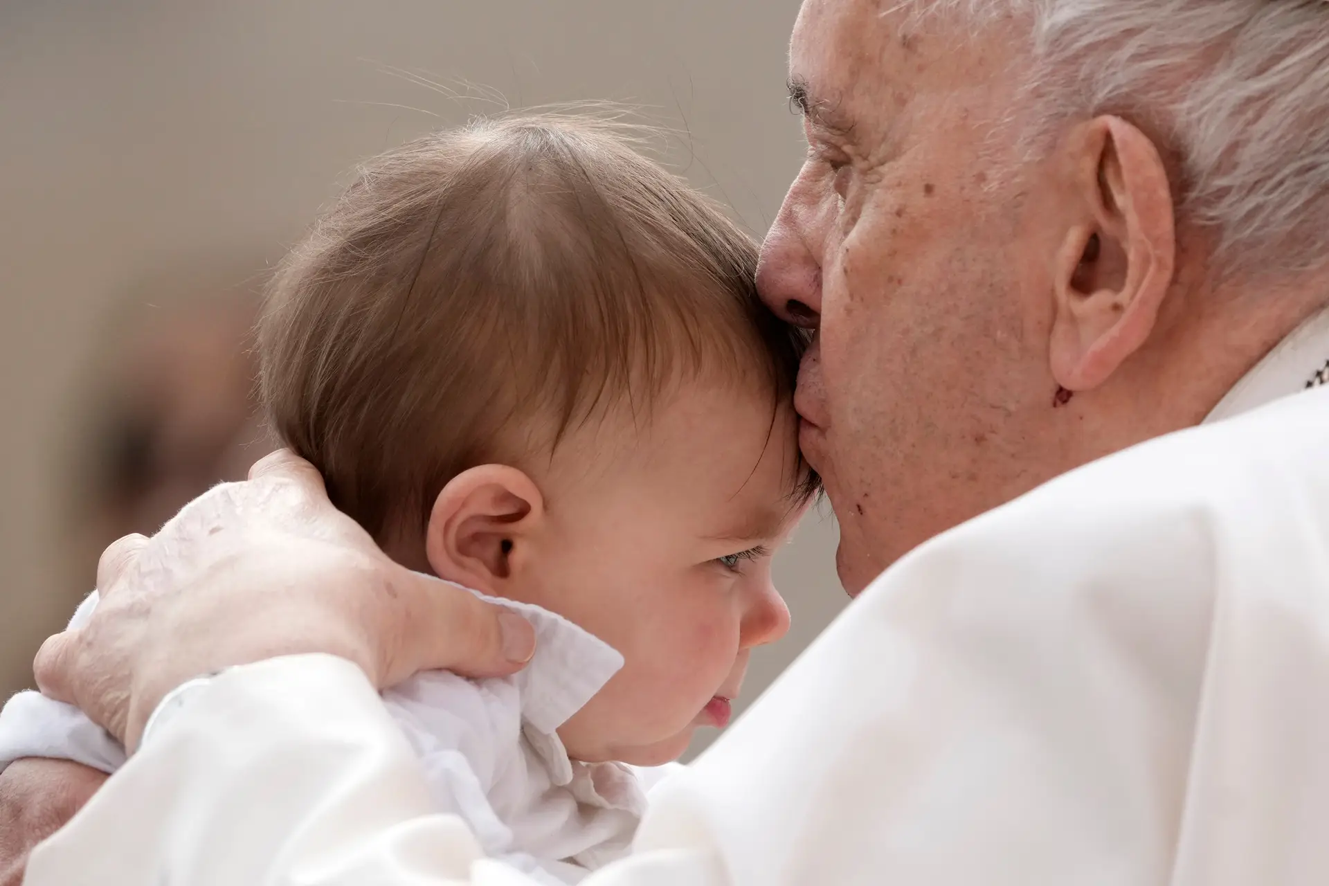 Papa Francisco beija uma criança no final da audiência semanal na Praça de São Pedro no Vaticano, 8 de março de 2023