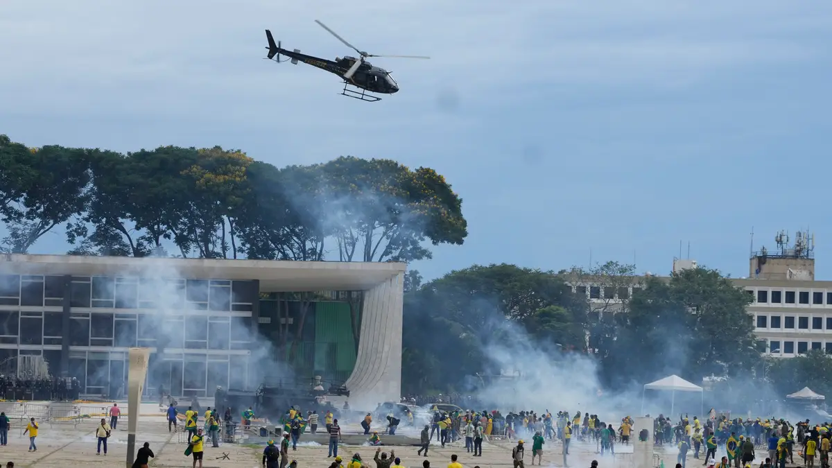 Manifestantes, apoiantes do antigo Presidente do Brasil, Jair Bolsonaro, confrontam-se com a polícia enquanto invadem o Palácio do Planalto, sede oficial de trabalho do Presidente, em Brasília, Brasil, no domingo, 8 de janeiro de 2023.