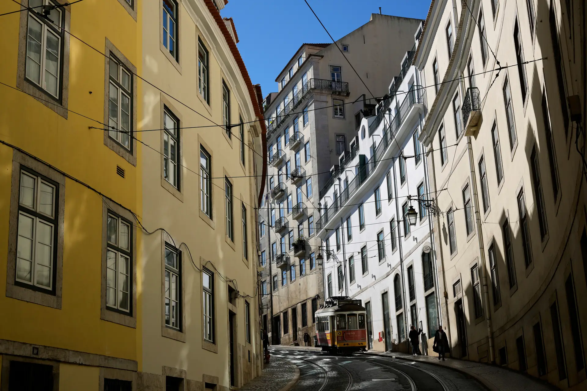 Elétrico desce rua em Lisboa.