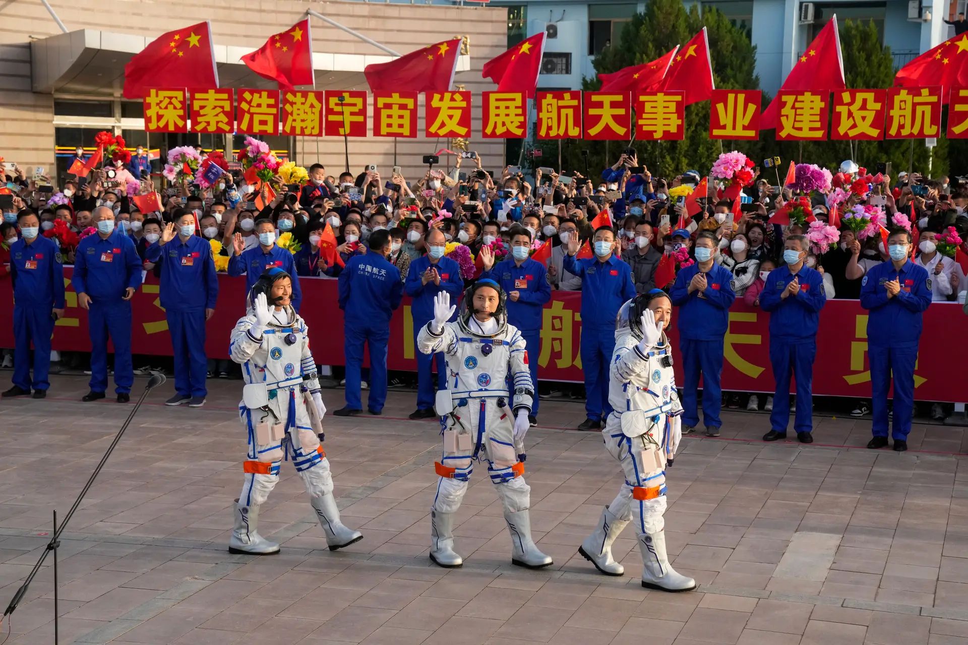 Os astronautas chineses da missão Shenzhou-16 acenam durante uma cerimónia de despedida da sua missão espacial tripulada no Centro de Lançamento de Satélites de Jiuquan, no noroeste da China.