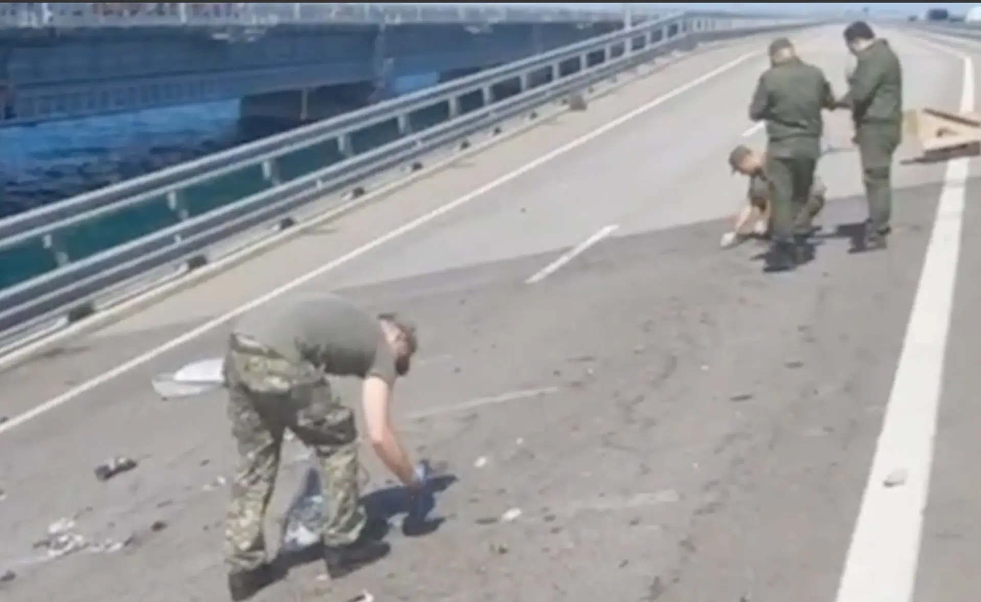 Imagem retirada de um vídeo distribuído pelo Comité de Investigação da Rússia de investigadores a examinar os danos na Ponte Kerch que liga a Crimeia à Rússia continental.