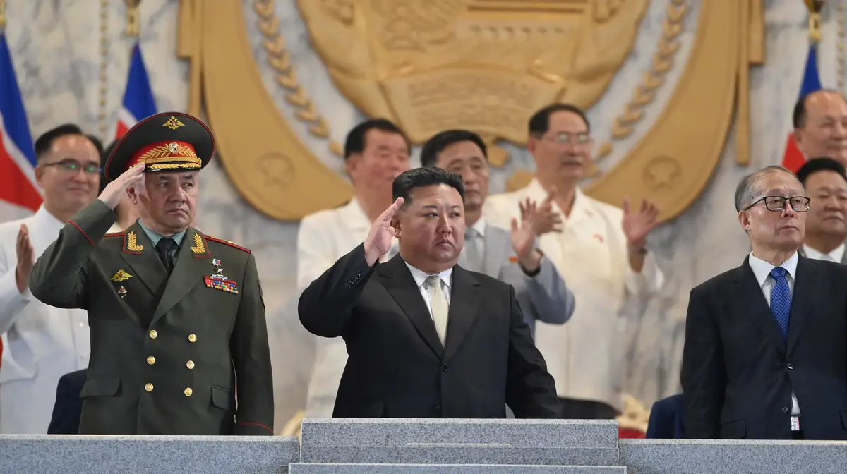 O líder da Coreia do Norte Kim Jong Un ladeado pelo ministro da Defesa russo, Sergei Shoigu (esq.) e um alto responsável do politburo chinês Li Hongzhong.
