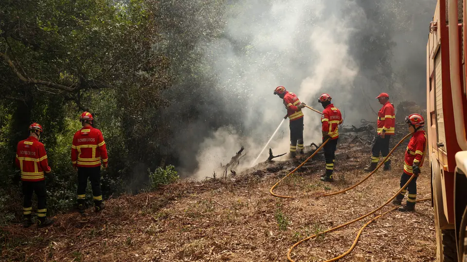 Bombeiros combatem incêndio.