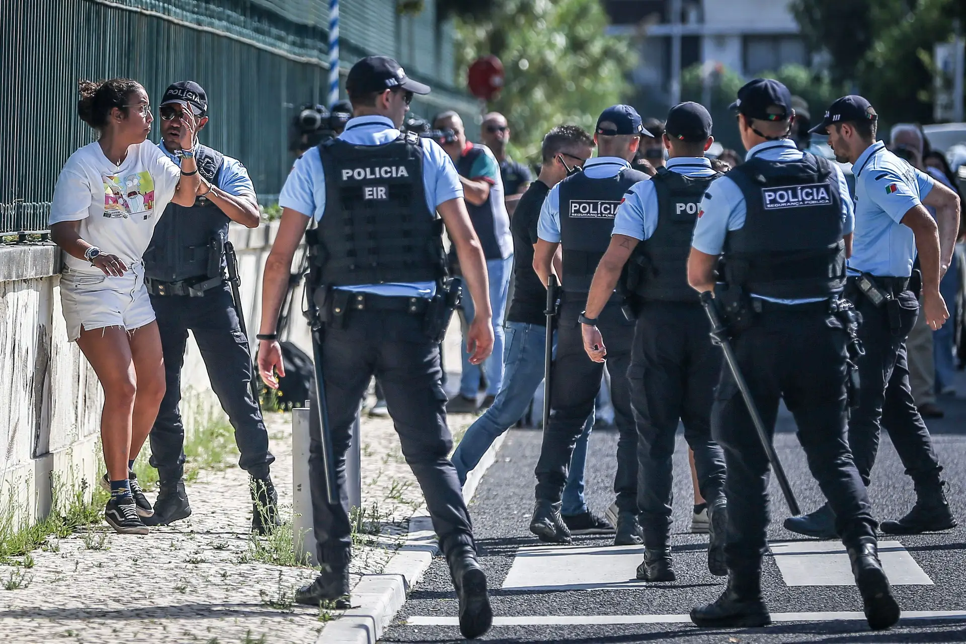 Agentes da Polícia de Segurança Pública detêm uma ativista durante marcha de protesto, em Oeiras.