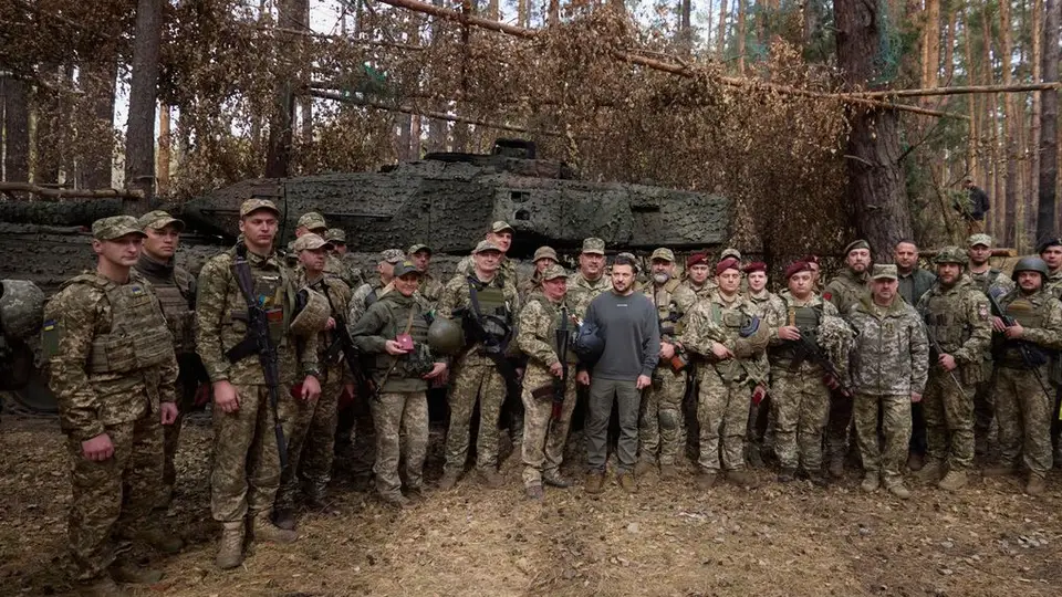 O presidente ucraniano, Volodymyr Zelenskyy com os soldados ucranianos em frente a um tanque Leopard 2, na linha de frente na região de Kharkiv, Ucrânia