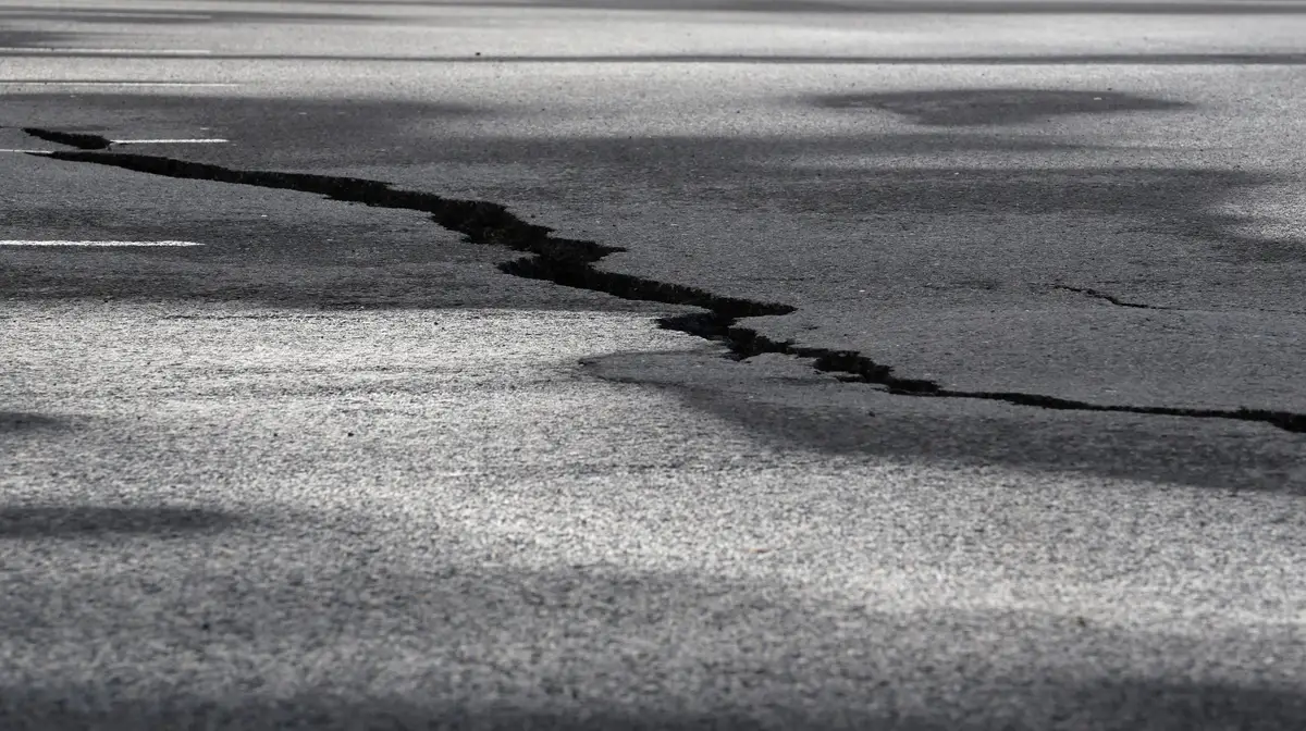 Uma estrada danificada em Grindavik, que foi evacuada devido à atividade vulcânica