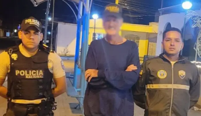 Colin Armstrong entre dois agentes da polícia