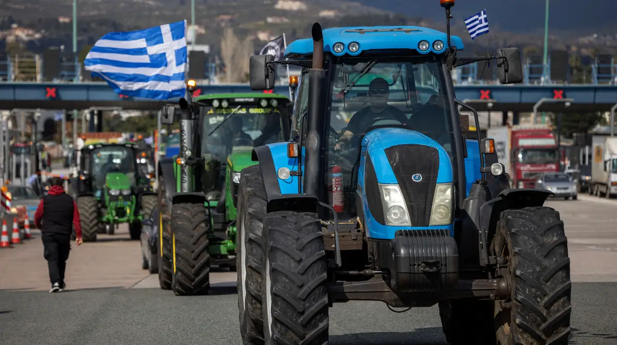 Agricultores gregos atravessam com os tratores uma estação de portagem enquanto se dirigem para Atenas, para se manifestarem sobre o aumento dos custos da energia e a concorrência das importações, em Afidnes, Grécia