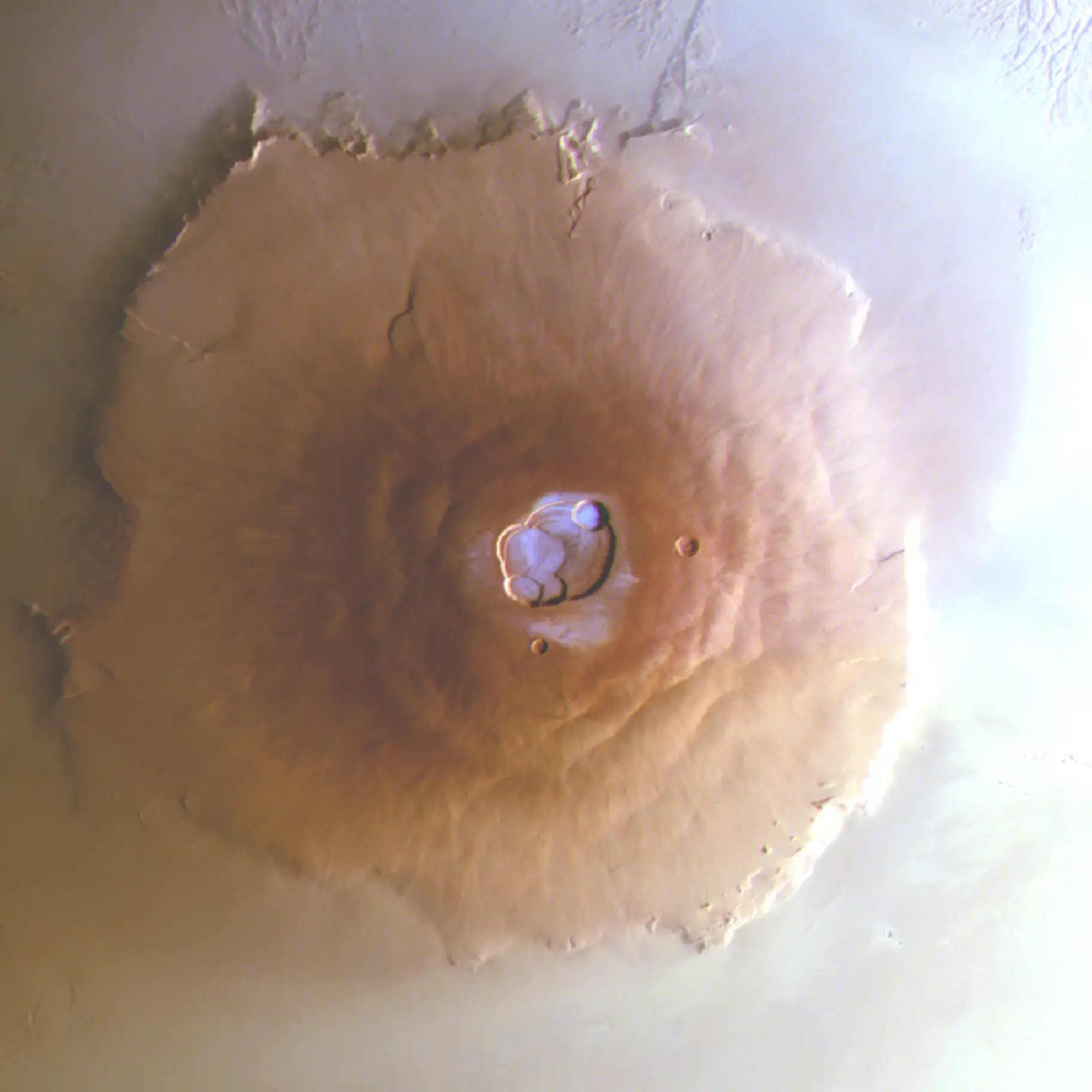 Vista aérea do vulcão Olympus Mons na superfície marciana. No topo do vulcão há uma cavidade - a caldeira - dentro da qual está o gelo branco-azulado.